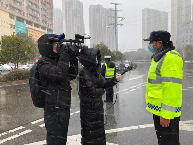 孝感市融媒體中心楊亞玲（風(fēng)雪中，采訪疫情期間重返一線的退休警察）_副本.jpg.jpg